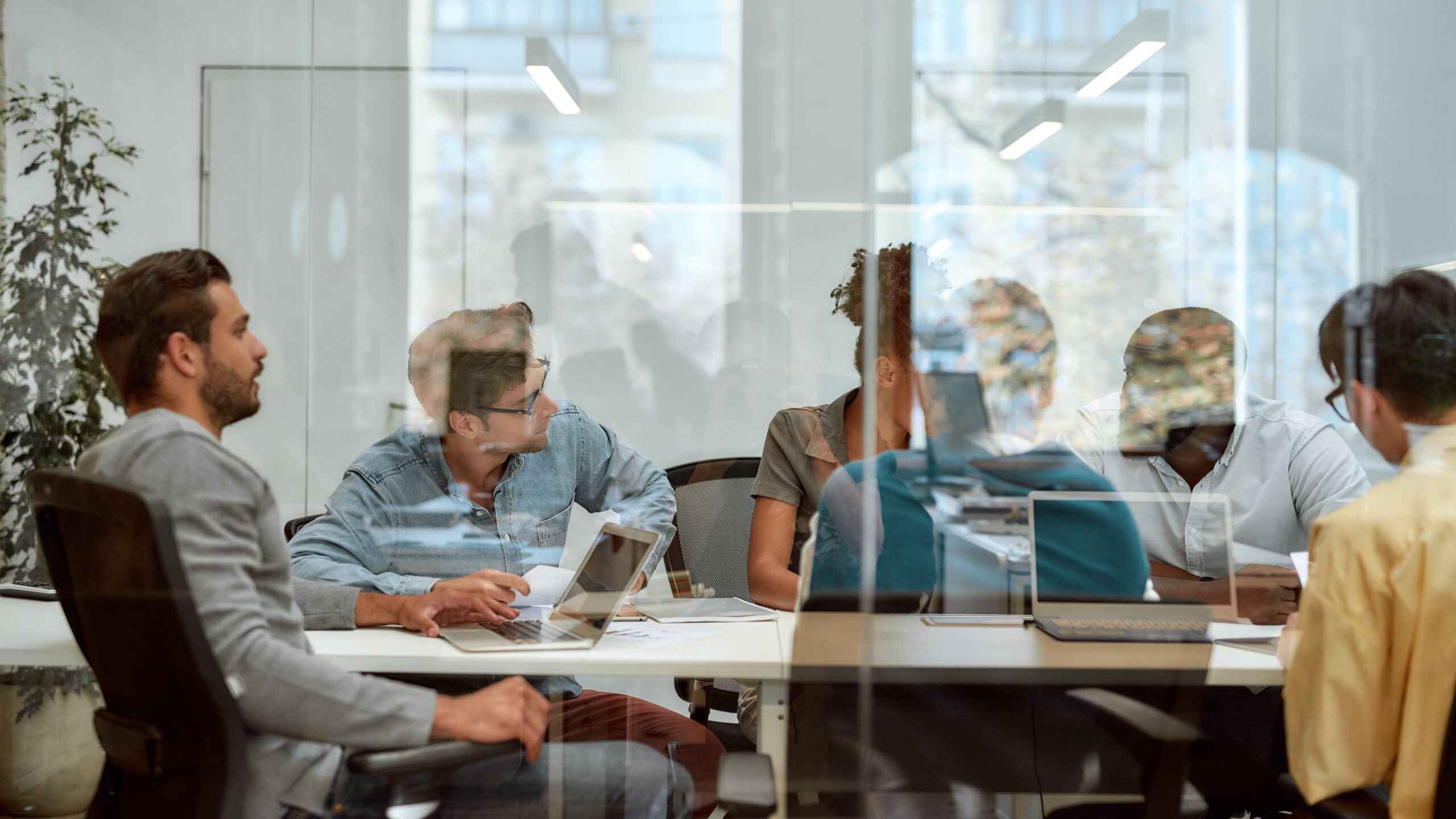 Setting Goals. Group of business people communicating and discussing fresh ideas while sitting together behind the glass wall in the meeting room Setting Goals. Group of business people communicating and discussing fresh ideas while sitting together behind the glass wall in the meeting room. Teamwork. Office life. Teamwork concept